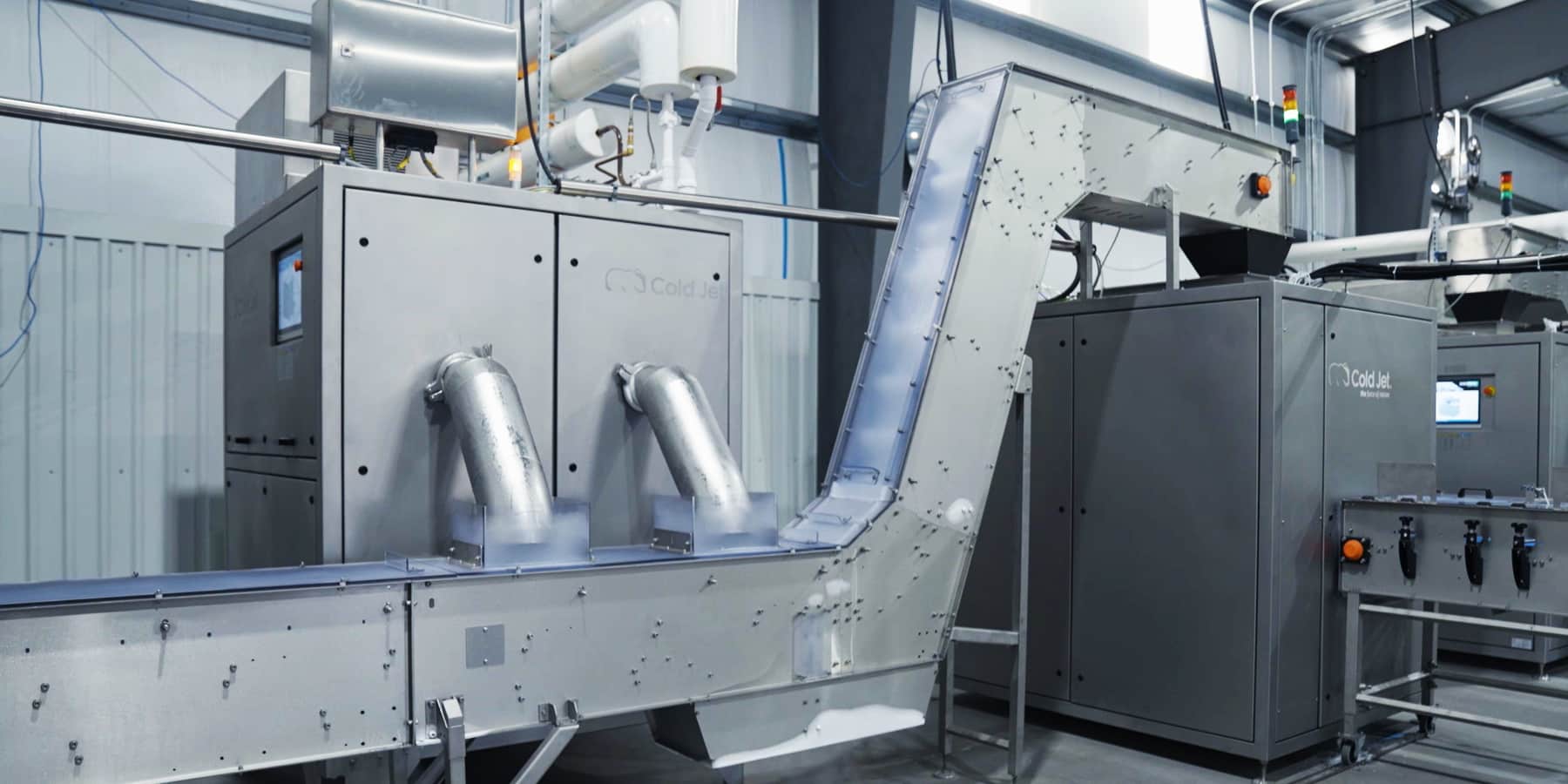 Silberner, industrieller Reformer mit Rohren und Rampe in einer Lagerhalle.