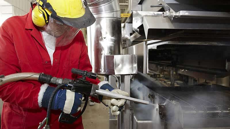 worker using dry ice blasting machine to clean restaurant equipment