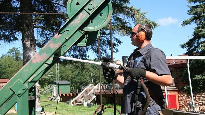 man using dry ice blasting machine to clean farm equipment